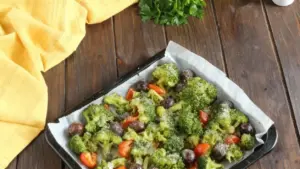 Teglia con broccoli, pomodorini e olive al forno su carta da forno