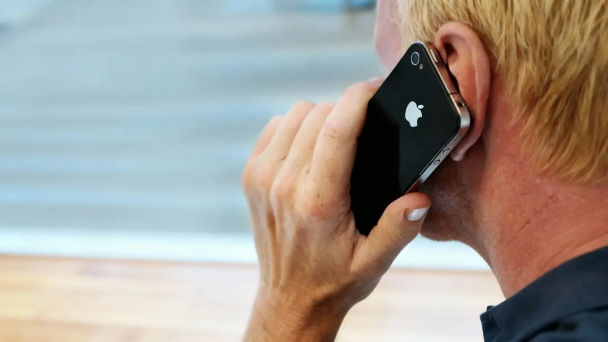 Persona al telefono con uno smartphone, di spalle