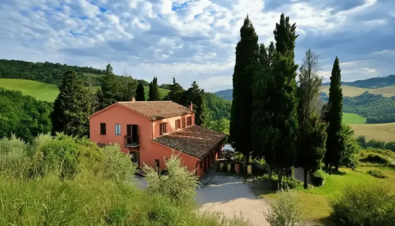 Agriturismo immerso nel verde delle colline con cipressi e vegetazione mediterranea